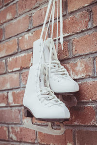 Close-up of shoes on brick wall