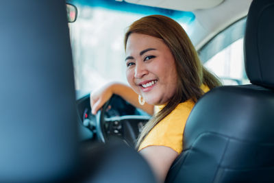 Portrait of smiling woman sitting in car