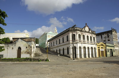 Buildings in city against cloudy sky