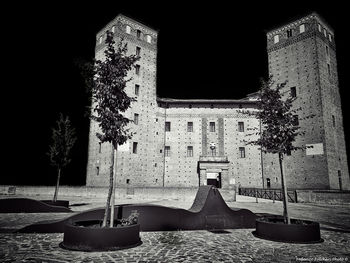 Tilt image of illuminated building against clear sky at night