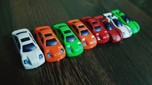 High angle view of colorful toy cars on wooden table