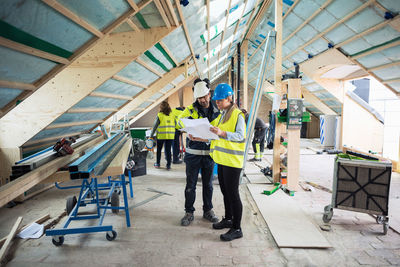 Construction managers planning while standing in messy site