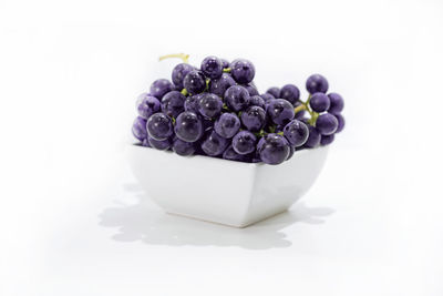 High angle view of black berries over white background