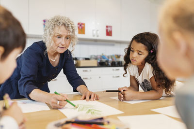 Senior teacher with students in drawing class