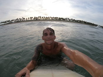 Portrait of man with surfboard in sea