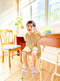 Young woman sitting on chair at home