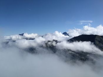 Low angle view of clouds covering mountains against sky