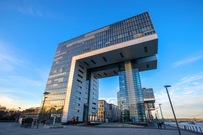 Low angle view of modern building against blue sky