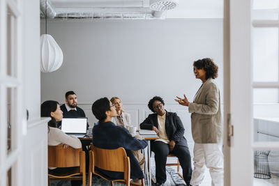 Businesswoman explaining ideas in meeting to coworkers at office