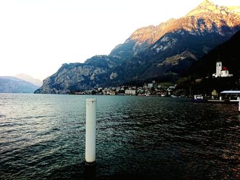 Scenic view of sea by mountains against clear sky