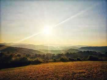 Scenic view of landscape against bright sun