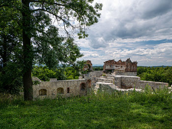 Old building on field against cloudy sky