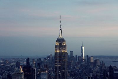 Modern buildings in city against sky during sunset