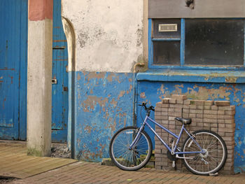 Bicycle against blue wall in city