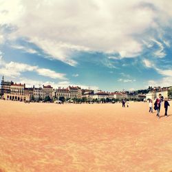 People at observation point against cloudy sky