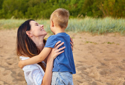 Side view of mother and son on land