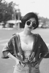 Portrait of sensuous woman wearing sunglasses while standing on road