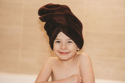 Joyful child in the bathroom with a towel on his head. children hygiene.