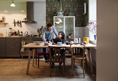 Father helping son in doing homework at home