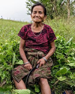 Portrait of smiling woman sitting on field