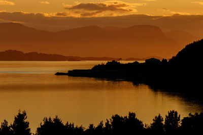 Scenic view of silhouette mountains against orange sky