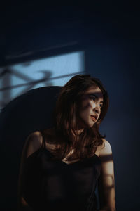 Young woman looking down while sitting in hair