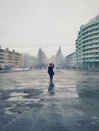 View of city street against cloudy sky