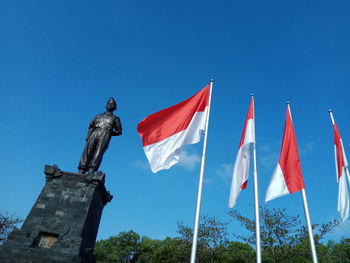 Low angle view of flags against blue sky in bali