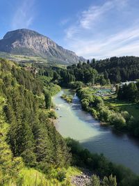 Scenic view of river by mountains against sky