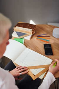 High angle view of man holding paper at table