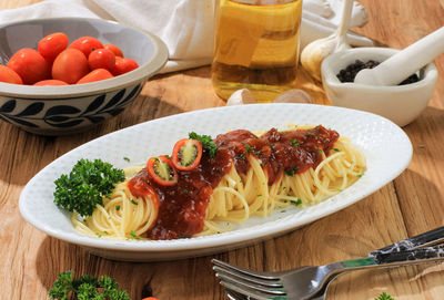 Delicious spaghetti served on white oval plate. 