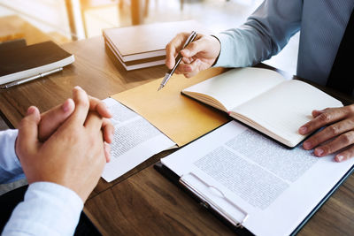 High angle view of man reading book on table