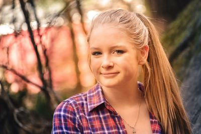 Portrait of smiling young woman in forest