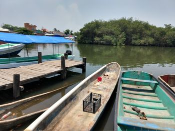 Boats moored on lake against sky