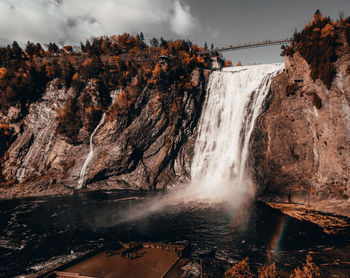 Scenic view of waterfall against sky