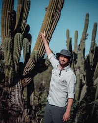 Full length portrait of young man standing against sky