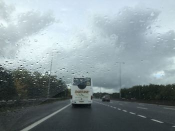 Road seen through wet windshield during rainy season