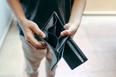 Midsection of man showing empty wallet