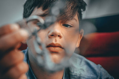 Close-up portrait of boy holding camera