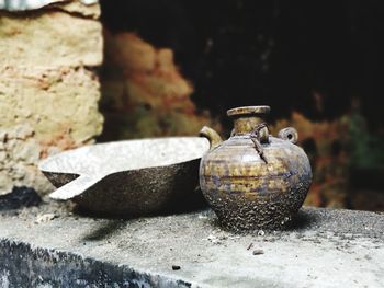 Close-up of rusty metallic containers on retaining wall