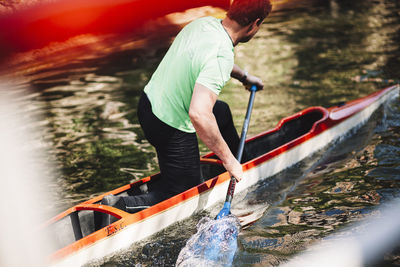 Rear view of man surfing in river