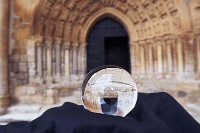 Close-up of person holding glass of building