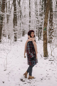 Rear view of woman standing on snow covered field