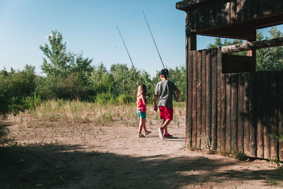 Siblings walking on field