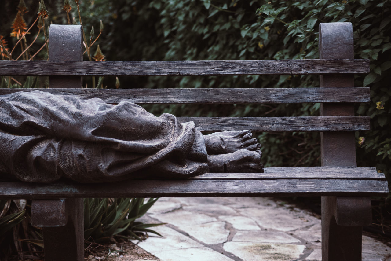 CLOSE-UP OF STATUE AGAINST WOODEN RAILING