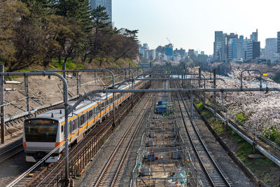 Railroad tracks in city against sky