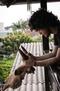Side view of boy looking through window