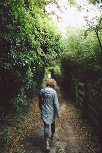 Rear view of woman walking on footpath