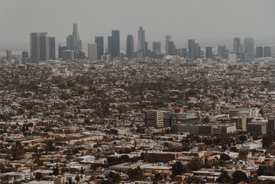 Aerial view of buildings in city against sky