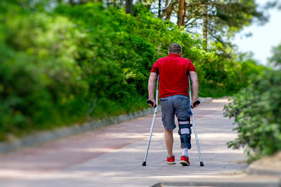 Rear view of man walking on road